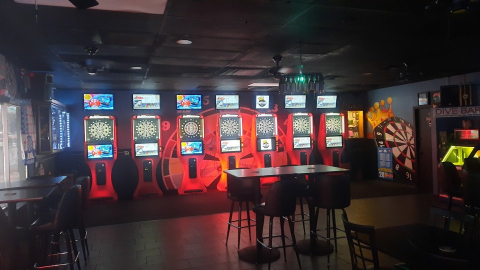 Casual bar tables with sports screens nearby.